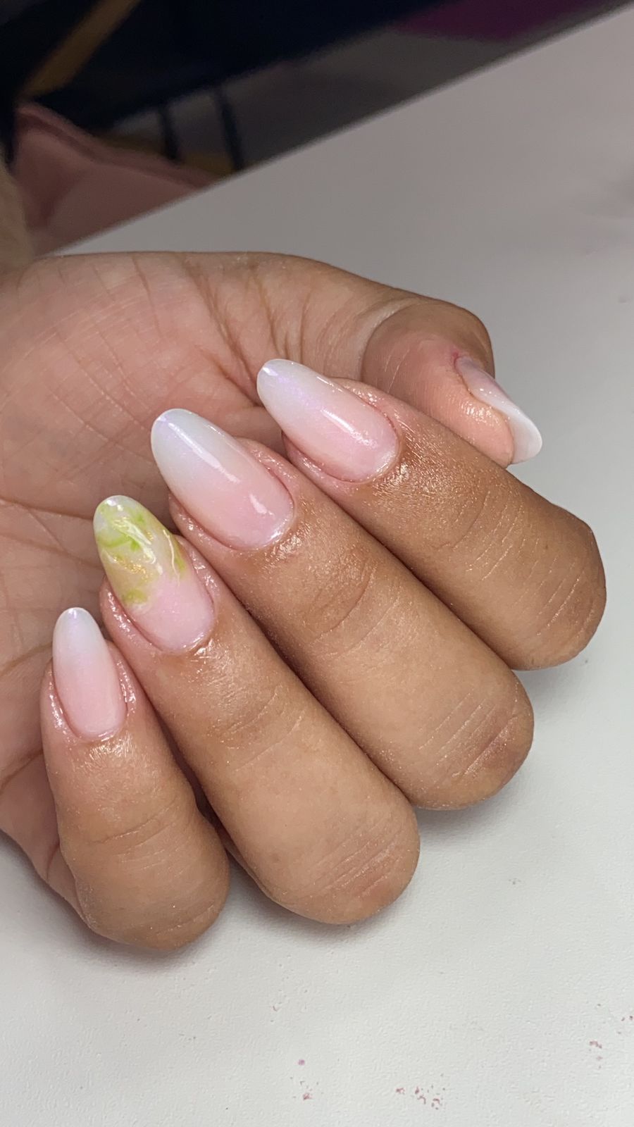 Mão de uma cliente mostrando suas unhas feitas em gel