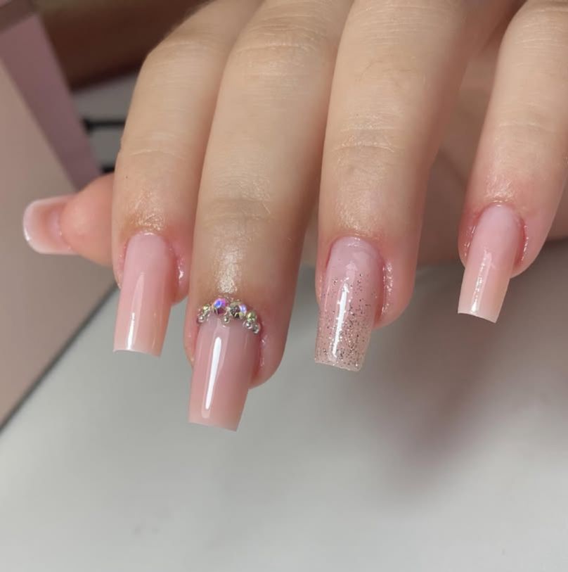 Mão de uma cliente mostrando suas unhas feitas em gel
