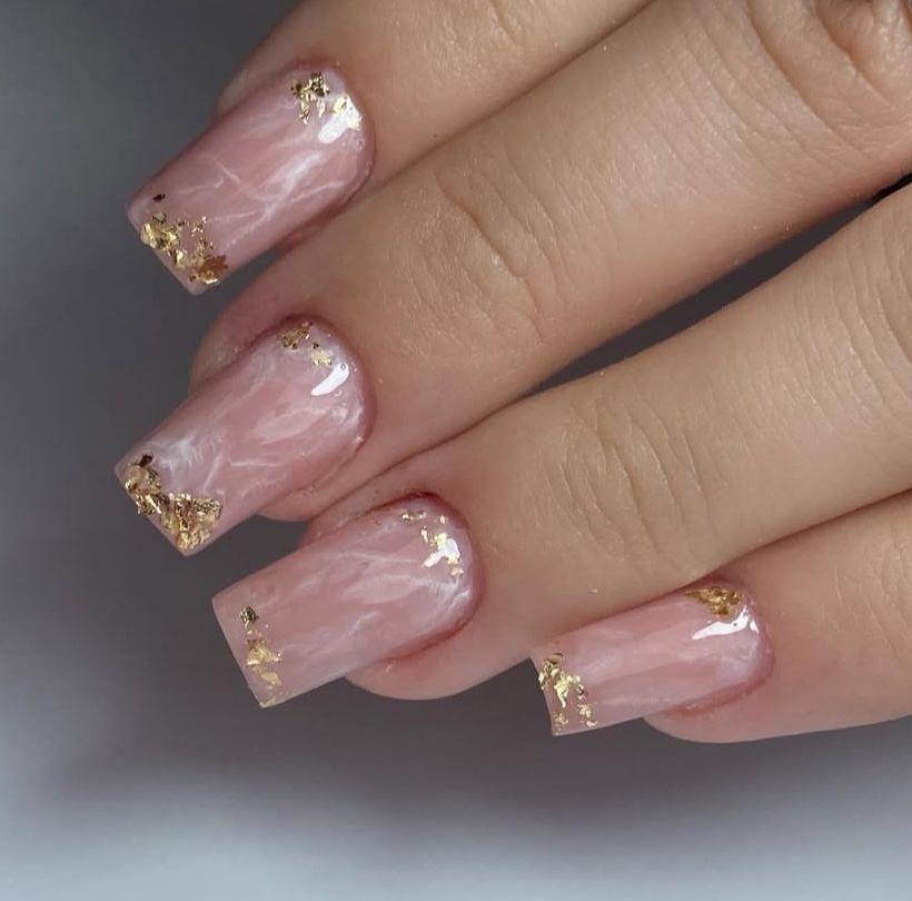 Mão de uma cliente mostrando suas unhas feitas em gel